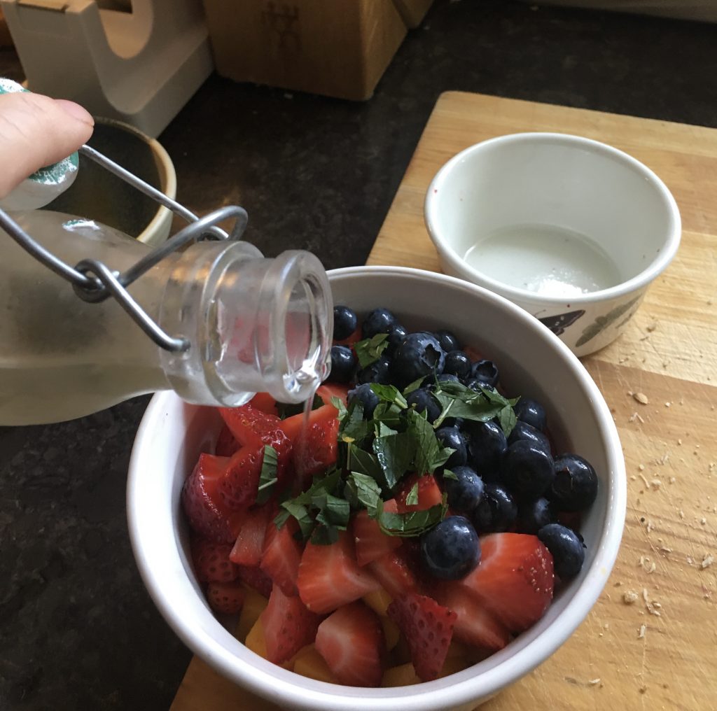 pouring simple syrup into fruit salad